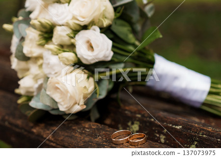 White Rose Wedding Bouquet with Gold Rings on Rustic Wood Background White Rose Wedding Bouquet with Gold Rings on Rustic Wood Background 137073975