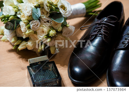 Elegant White Rose Bridal Bouquet with Black Leather Dress Shoes and Perfume Bottle on Wooden Surface Elegant White Rose Bridal Bouquet with Black Leather Dress Shoes and Perfume Bottle on Wooden Surface 137073984