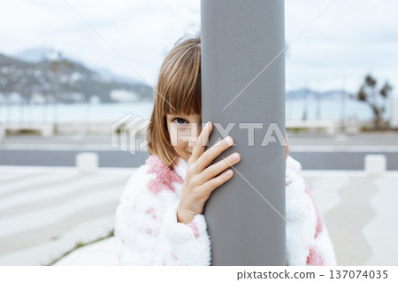little cute blond girl curious smiling playing outside on sea, lifestyle people concept little cute blond girl curious smiling playing outside on sea, lifestyle people concept 137074035