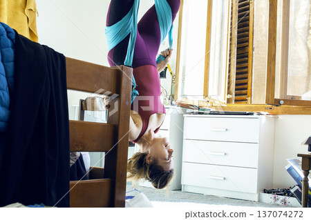 young woman doing aerial yoga at home, lifestyle people concept young woman doing aerial yoga at home, lifestyle people concept 137074272
