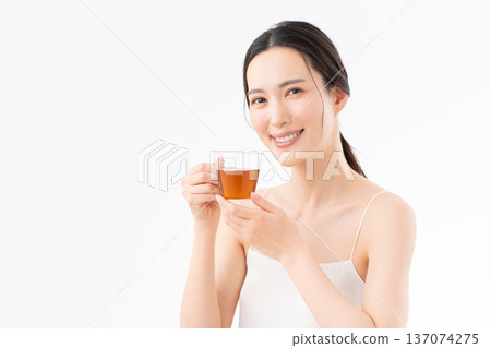 Healthy image of a woman drinking tea on a white background Healthy image of a woman drinking tea on a white background 137074275