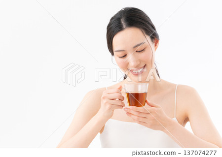 Healthy image of a woman drinking tea on a white background Healthy image of a woman drinking tea on a white background 137074277