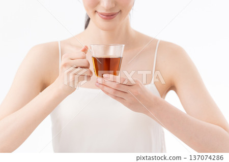 Healthy image of a woman drinking tea on a white background 137074286