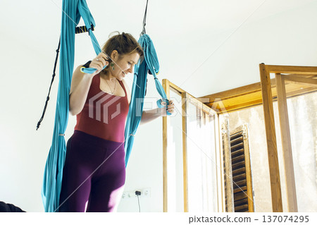 young woman doing aerial yoga at home, lifestyle people concept young woman doing aerial yoga at home, lifestyle people concept 137074295