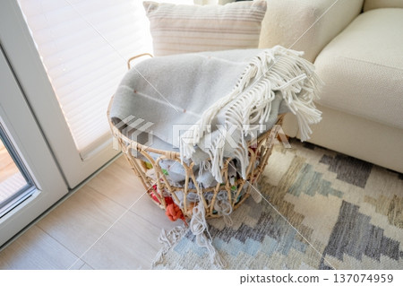 Woven rattan basket with cozy blankets and yarn in Scandinavian home interior Woven rattan basket with cozy blankets and yarn in Scandinavian home interior 137074959