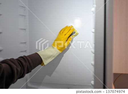 Manual freezer cleaning with protective glove and sponge during defrosting Manual freezer cleaning with protective glove and sponge during defrosting 137074974