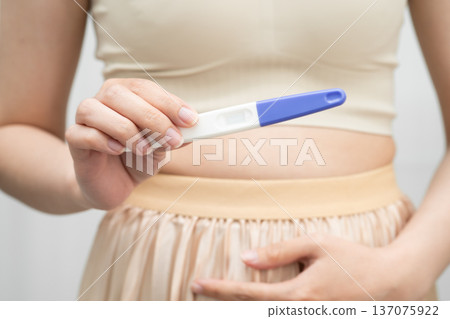 Asian holding pregnancy test for female of ovulation day, fetus, maternity, childbirth, birth control. 137075922