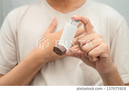 Asthma and chronic obstructive pulmonary disease COPD, Asian young man using metered dose inhaler MDI. 137075928
