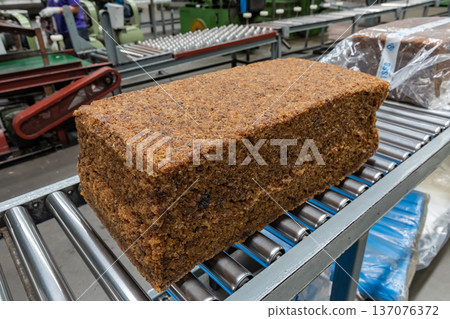 The close up image of the jagged brown natural raw rubber bales surface, lumpy solid block standard Thai rubber, in a factory. 137076372