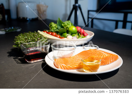Ingredients of Spicy Raw Salmon are prepared on granite top table such as lemonglass tomato lemon garlic chilli salt oil and wasabi on dishes. 137076383