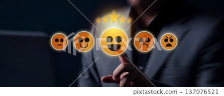 A hand selects a positive emoji on a touchscreen interface, triggering a five star customer rating within an interactive digital review system. 137076521