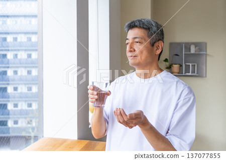 一位老人在窗邊吃藥 137077855