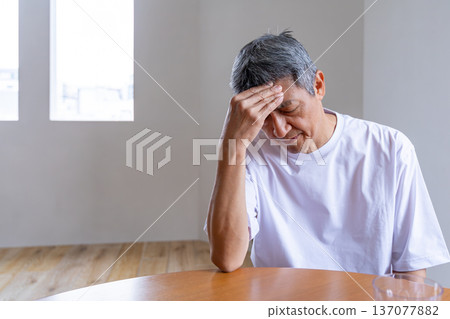 客廳裡,一位老人抱著頭 客廳裡,一位老人抱著頭 137077882