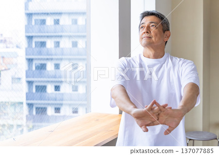 Senior man stretching by the window Senior man stretching by the window 137077885