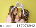 Funny friendly girls dressed up as Easter bunnies on the eve of the holiday 137078942