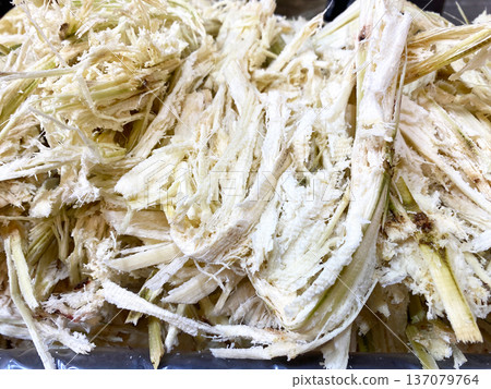 Cane pulp displayed in a pile after extraction from sugarcane, showcasing fibrous texture and natural color, ready for further processing or use in various products 137079764