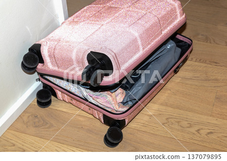 Pink glitter childrens suitcase for girls, open and packed indoors. 137079895
