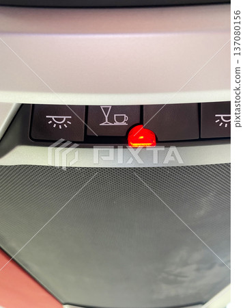 Control panel inside a bus featuring illuminated warning lights for passenger service indicators, including seatbelt and refreshment symbols 137080156