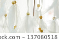 White feathers and wooden beads hanging from a dreamcatcher, creating a soft, ethereal backdrop in bright, airy light, representing peace, spirituality, and good dreams 137080518