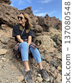 Female tourist sitting on a rock hiking in a fortress Tenerife Spain 137080548