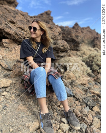 Female tourist sitting on a rock hiking in a fortress Tenerife Spain Female tourist sitting on a rock hiking in a fortress Tenerife Spain 137080548