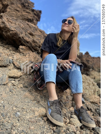 A happy tourist walks in a park near a volcano on the island of Tenerife, Spain A happy tourist walks in a park near a volcano on the island of Tenerife, Spain 137080549