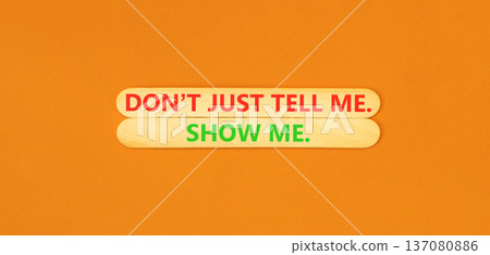 Tell or show symbol. Concept words Do not just tell me, show me beautiful wooden sticks. Beautiful orange background. Business tell or show concept. Copy space. 137080886