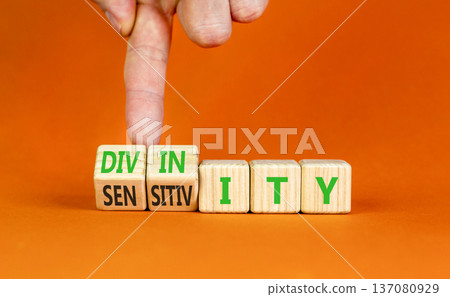 Sensitivity or divinity symbol. Concept words Sensitivity or Divinity on wooden cubes. Beautiful orange background. Psychologist hand. Psychology sensitivity or divinity concept. Copy space. 137080929