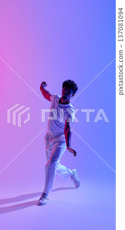 Young male cricket player throwing ball in neon gradient studio light Young male cricket player throwing ball in neon gradient studio light 137081094