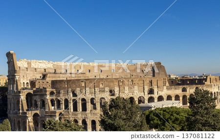 Famous Coliseum in Rome. Colosseum, or Coliseum. Sunset at huge Roman amphitheatre, Rome, Italy, Europe. Famous touristic place in the world and Europe. Beautiful blue sky background. Famous Coliseum in Rome. Colosseum, or Coliseum. Sunset at huge Roman amphitheatre, Rome, Italy, Europe. Famous touristic place in the world and Europe. Beautiful blue sky background. 137081122