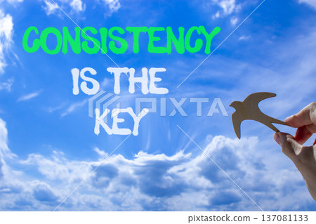 Consistency is the key symbol. Concept words Consistency is the key on beautiful blue sky. Beautiful blue sky background. Businessman's hand. Business consistency is the key concept. Copy space. 137081133