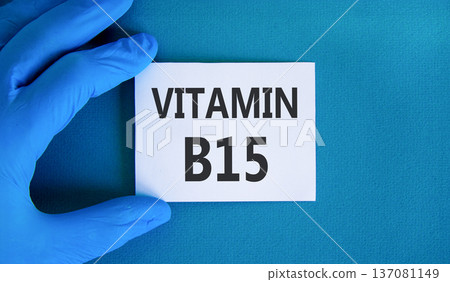 Vitamin B15 pantothenic acid symbol. Concept words Vitamin B15 on beautiful white card. Doctor's hand in blue medical glove. Beautiful blue background. Medical healthy lifestyle Vitamin B15 concept. Vitamin B15 pantothenic acid symbol. Concept words Vitamin B15 on beautiful white card. Doctor's hand in blue medical glove. Beautiful blue background. Medical healthy lifestyle Vitamin B15 concept. 137081149