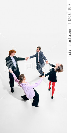 Business team in tailored suits holding hands in circle on white background in modern office styling. Business team in tailored suits holding hands in circle on white background in modern office styling. 137081199