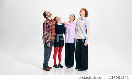 Four models standing close together in contemporary everyday outfits on white studio background. Four models standing close together in contemporary everyday outfits on white studio background. 137081241