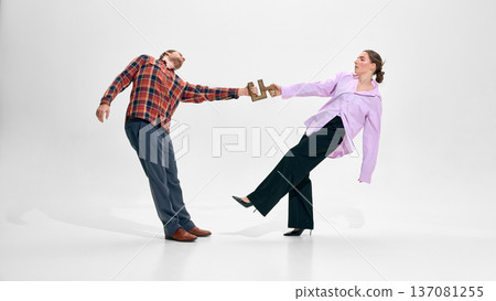 Business partners pulling opposite directions holding puzzle piece. 137081255