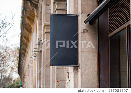 Blank shop sign presenting an ideal mock up for branding, advertising, or displaying information for a business on a stone building in an urban environment Blank shop sign presenting an ideal mock up for branding, advertising, or displaying information for a business on a stone building in an urban environment 137081597