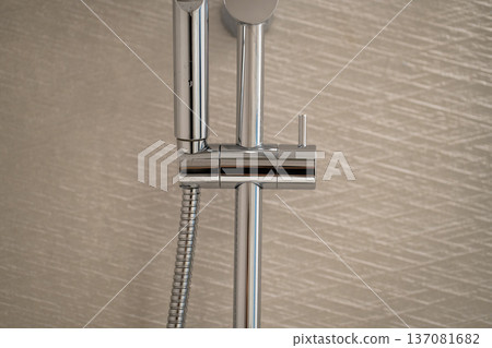 Modern chrome shower head and rail system for a contemporary bathroom, highlighting sleek metallic design and stylish plumbing fixtures Modern chrome shower head and rail system for a contemporary bathroom, highlighting sleek metallic design and stylish plumbing fixtures 137081682