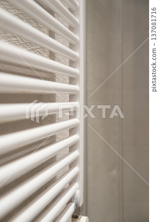 White towel radiator providing warmth and comfort in a modern bathroom, creating a minimalist concept for heating and interior design elements White towel radiator providing warmth and comfort in a modern bathroom, creating a minimalist concept for heating and interior design elements 137081716