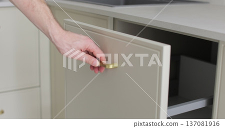 Handyman installing and adjusting drawer slide mechanism in contemporary kitchen. Furniture installation. Handyman installing and adjusting drawer slide mechanism in contemporary kitchen. Furniture installation. 137081916
