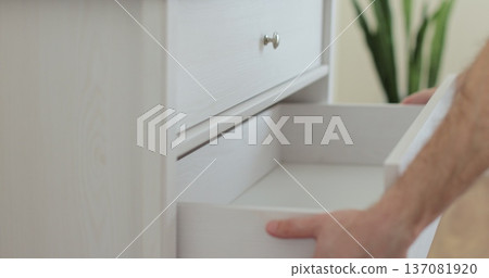 Handyman installing and adjusting drawer slide mechanism in contemporary kitchen. Furniture installation. Handyman installing and adjusting drawer slide mechanism in contemporary kitchen. Furniture installation. 137081920