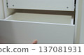 Handyman installing and adjusting drawer slide mechanism in contemporary kitchen. Furniture installation. 137081931