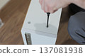 Man assembling kitchen drawer in modern cabinet using screwdriver. Furniture installation. 137081938