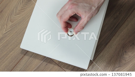 Young craftsman assembles furniture fittings. Professional furniture assembling. Installation of new furniture. Furniture assembly. 137081945