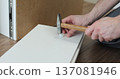 Man assembles furniture. Adult craftsman close-up hands does home repairs. 137081946