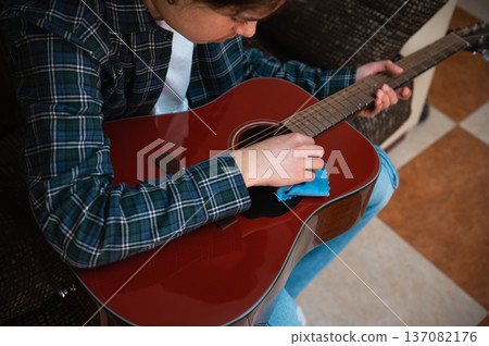 Teenage Boy Playing Acoustic Guitar At Home In Cozy Casual Setting Teenage Boy Playing Acoustic Guitar At Home In Cozy Casual Setting 137082176