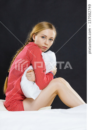 Sad depressed girl in bed gripping pillow 137082749