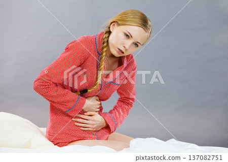 Sad young teenager woman on bed feeling pain Sad young teenager woman on bed feeling pain 137082751