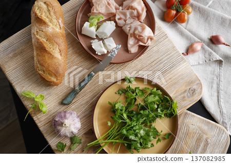 High-quality farm food on wooden cutting board. Top view. Flat lay photo. Soft goat cheese on bread, basil and mortadella sandwich. Italian tradition cuisine. High-quality farm food on wooden cutting board. Top view. Flat lay photo. Soft goat cheese on bread, basil and mortadella sandwich. Italian tradition cuisine. 137082985