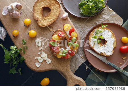 Round bruschetta with red and yellow cherry tomatoes and goat cheese on oak wooden board. Farm produce, crusty bread. Food and healthy eating. Round bruschetta with red and yellow cherry tomatoes and goat cheese on oak wooden board. Farm produce, crusty bread. Food and healthy eating. 137082986