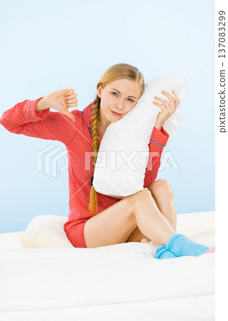 Young woman wearing pajamas hugging soft pillow 137083299